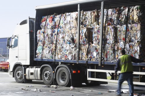 Workers handling builders waste clearance adhering to safety regulations